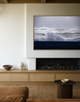 This image features a serene and stylish living room setting, accentuated by the art piece titled "Black Beach Lines". The artwork displays a powerful ocean wave, Its bold, monochrome design contrasting the dynamic texture of the sea with the stark, clean lines of the wave.