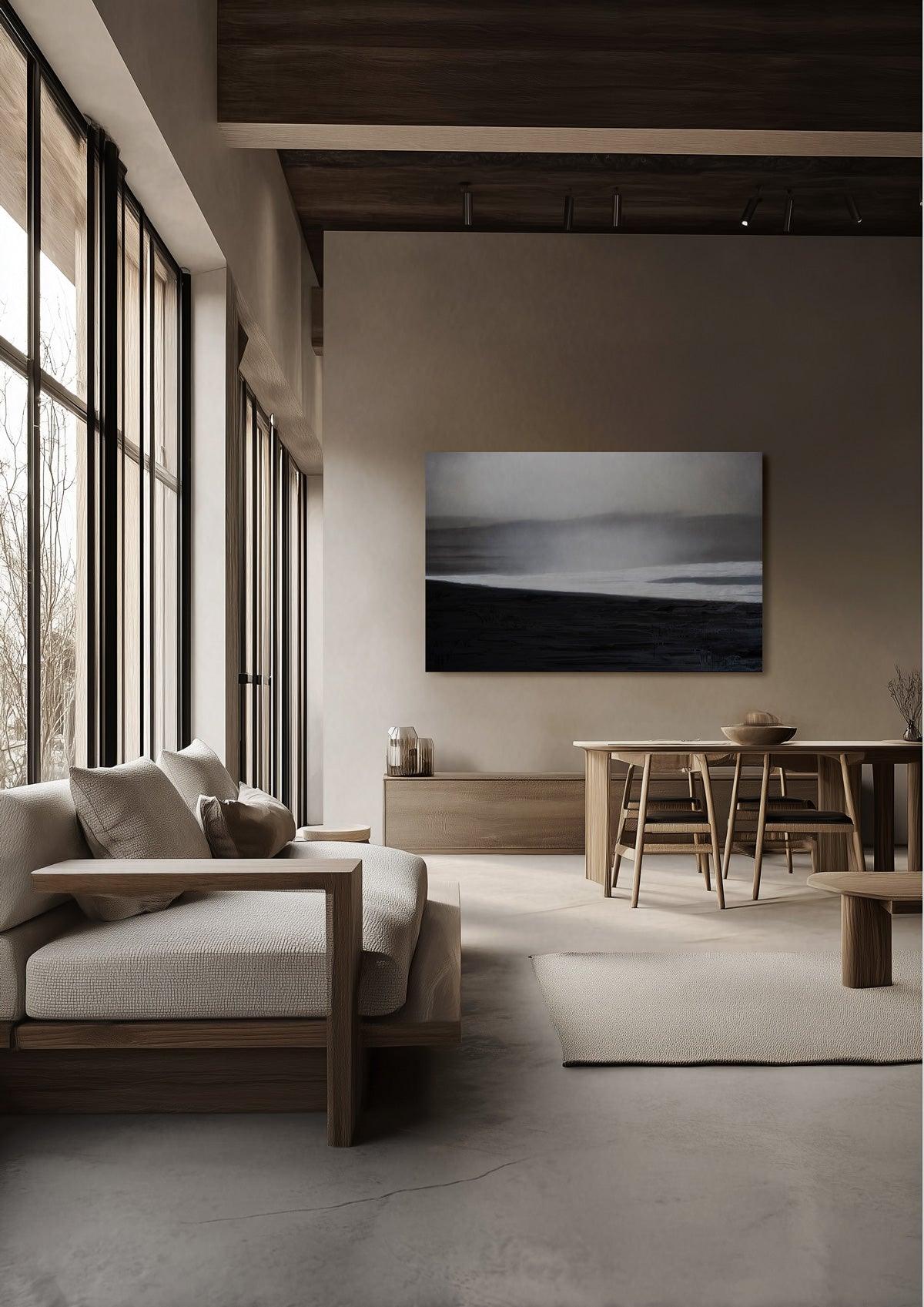 A zen living room with a seascape painting in black and white on the wall.