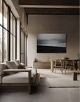 A zen living room with a seascape painting in black and white on the wall.