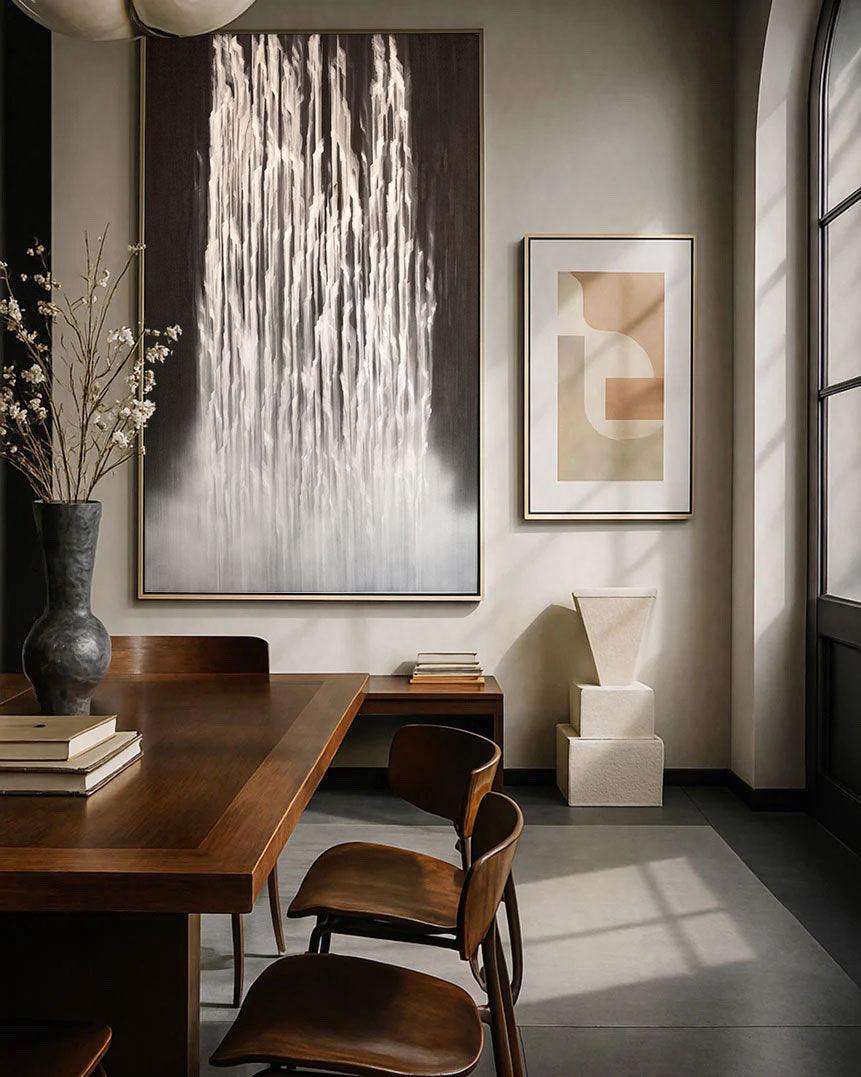 A painting titled 'Liberated Lines' featuring abstract white lines on a dark background, displayed on a wall above a wooden dining table and chairs.