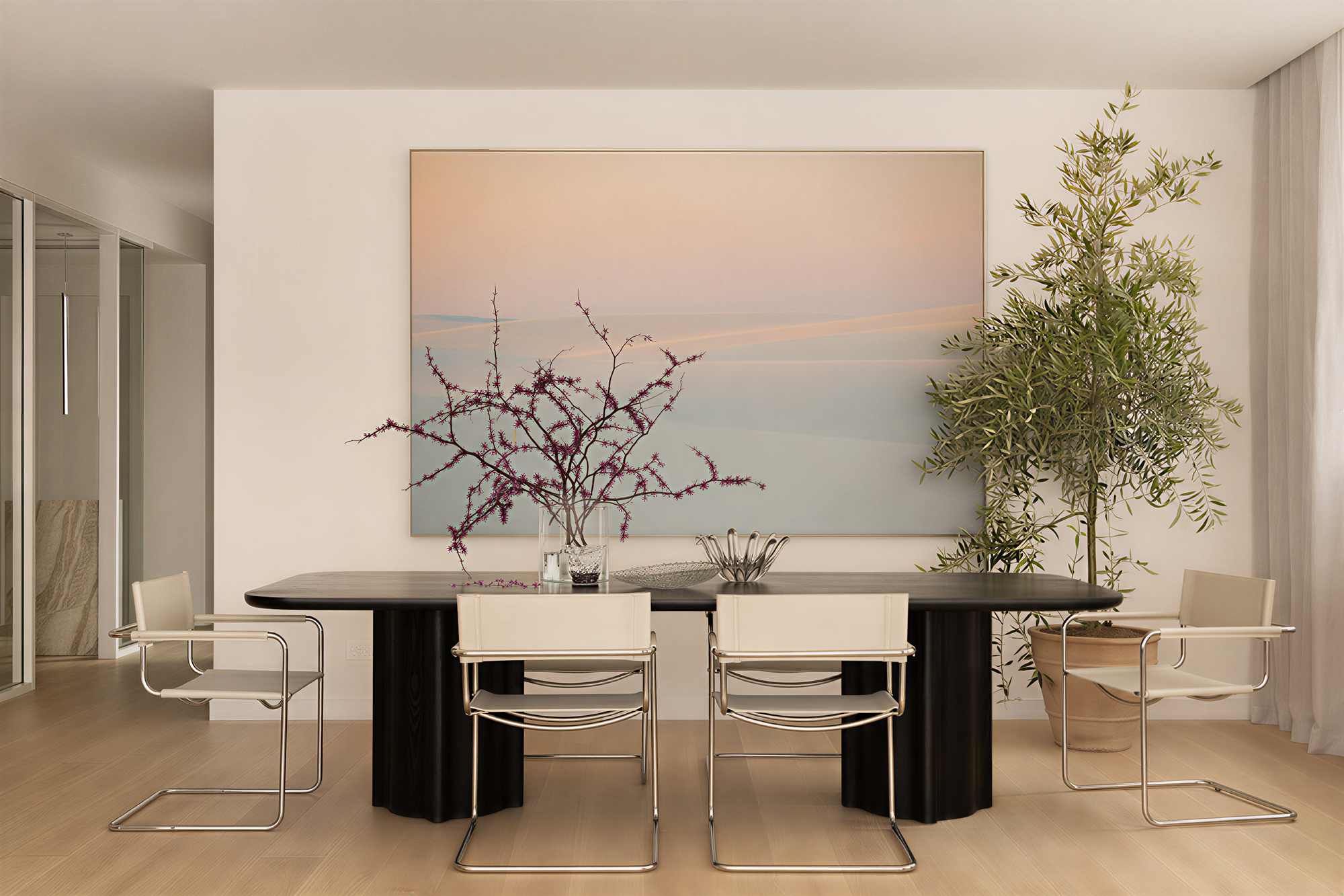 A dining room with a large painting of pink clouds.